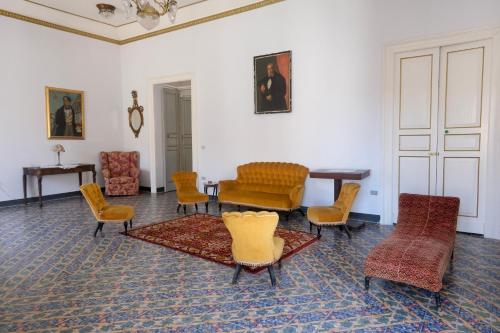 ein Wohnzimmer mit Stühlen, einem Tisch und einem Sofa in der Unterkunft Palazzo Falletti in Guardavalle