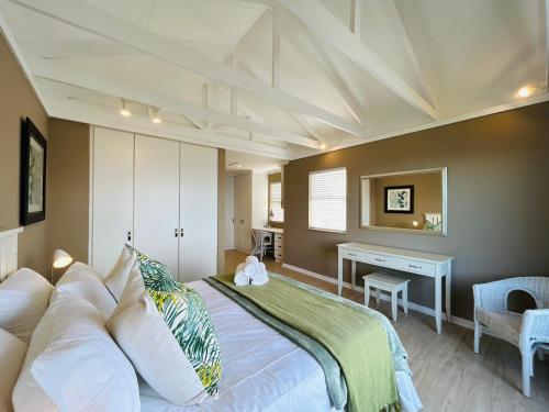 a bedroom with a large bed and a desk at Pinnacle Point Golf Estate - Golf Lodge 114 in Mossel Bay