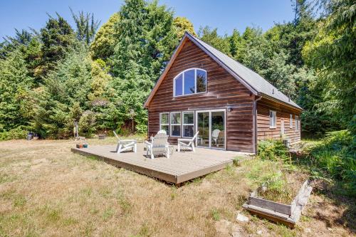 a log cabin with a deck and chairs on it at Gold Beach Vacation Rental Close to Beaches! in Ophir