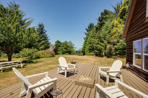 a wooden deck with chairs and a fire place at Gold Beach Vacation Rental Close to Beaches! in Ophir