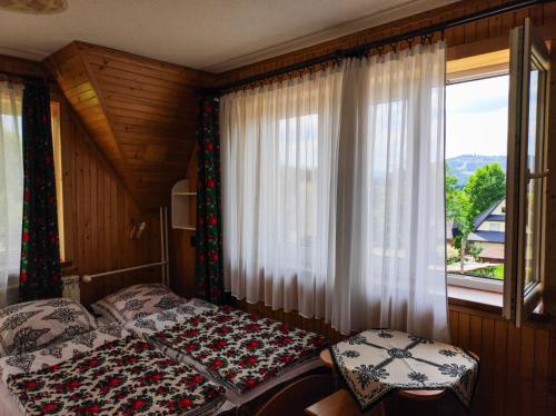 ザコパネにあるPokoje Gościnne Janinaのベッドルーム1室(ベッド2台、窓付)