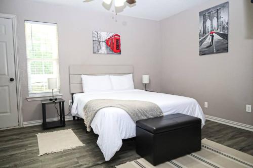 a bedroom with a white bed with a black stool at Comfy Two-Bedroom Apartment in Arlington in Arlington
