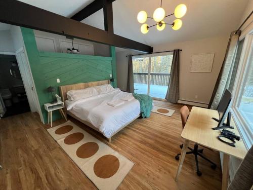 a bedroom with a bed and a desk with a computer at Stratton Tree House in Strattonwald