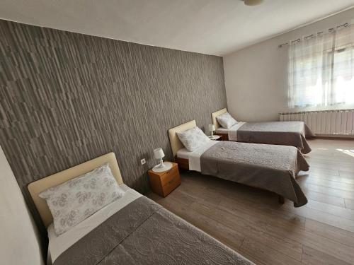 Cette chambre comprend 2 lits et une fenêtre. dans l'établissement Apartmani Stadion, à Zadar