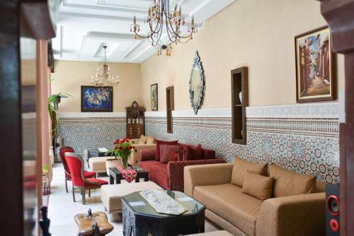 eine Lobby mit Sofas, Stühlen und einem Kronleuchter in der Unterkunft Riad Yacout in Meknès