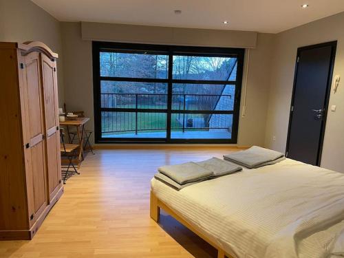 una camera con un letto e una grande finestra di Wilgentuin a Bekkevoort