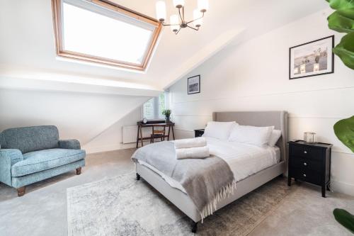 um quarto com uma cama e uma cadeira azul em 8 The Quadrant Luxury Apartments - Hoylake em Hoylake