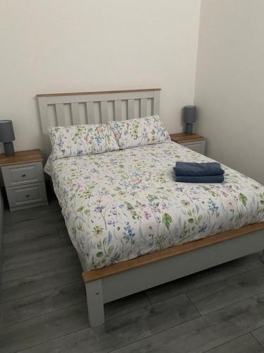 łóżko w sypialni z 2 stolikami nocnymi i 2 lampami w obiekcie Hill Top View Apartment Lahinch w mieście Lahinch