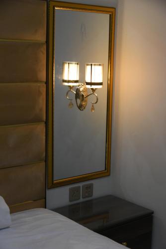 a bedroom with a mirror and a table with a bed at Hotel white season Gulberg in Lahore