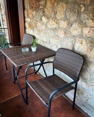 a table with two chairs and a table with a plant on it at Madame Parisienne in Nafpaktos