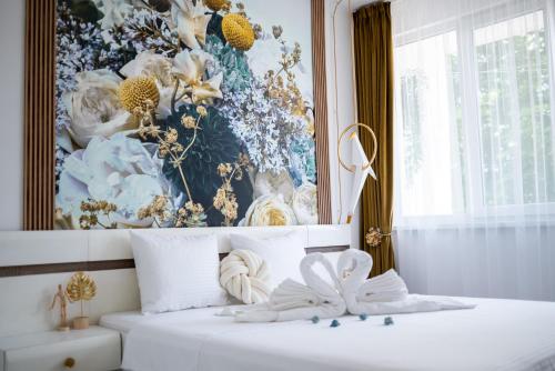 a bedroom with a painting of flowers on a bed at A&K KOZY ART Studio 2 in Varna City