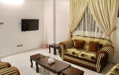 een woonkamer met een bank en een tafel bij شقه النزهه مكونه من غرفتين وصاله ودورتين مياه وغرفه طعام in Al Madinah