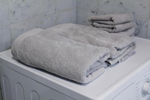 uma pilha de toalhas em cima de uma máquina de lavar roupa em Idas AirBnB em Helsinque