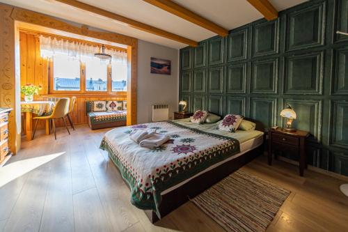 a bedroom with a large bed and a table at Apartamenty Parzenica in Zakopane