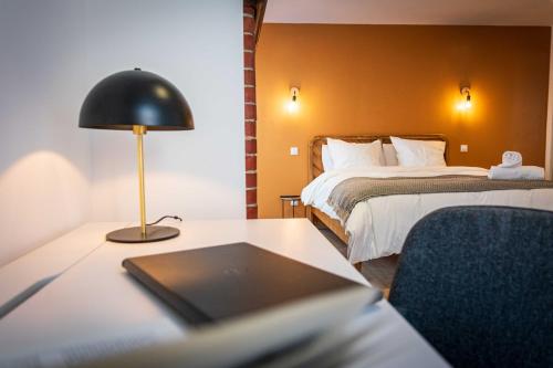 une chambre d'hôtel avec un lit et un ordinateur portable sur un bureau dans l'établissement L'Albatros 008 - Hypercentre Cosy Wifi, à Saint-Quentin