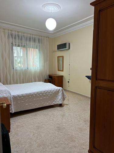 1 dormitorio con cama y ventana en Sfiha/Hoceima huis, en Alhucemas