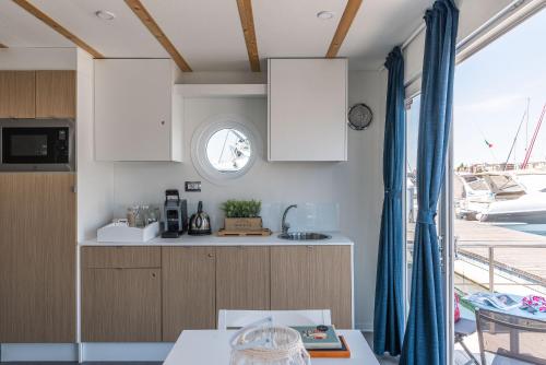 a kitchen with white cabinets and a window at Marina del Gargano Houseboat in Manfredonia