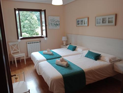 Dos camas en una habitación con toallas. en LOPENEA en Garzáin