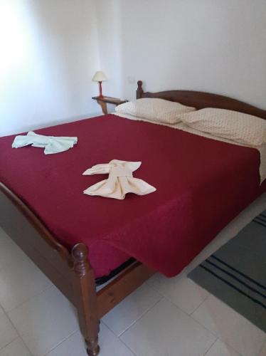 Un dormitorio con una cama con una manta roja y dos hambrientos en Agriturismo I 13 Pini di Putzu Anna Maria, en Giba