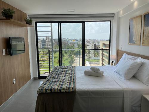 Un dormitorio con una cama grande con una ventana grande. en Bela Hospedagem - #Neo Duos 802 Charme em Intermares, en Cabedelo