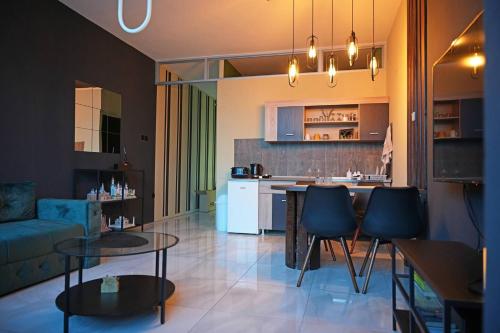 a kitchen and living room with a table and chairs at Diamond Apartments Niš in Niš