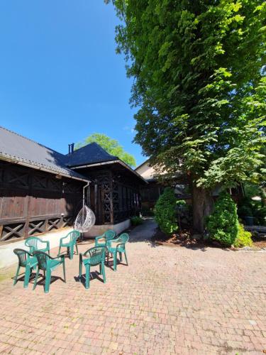 a group of green chairs sitting in a courtyard at Gościniec Błogocice in Cieszyn