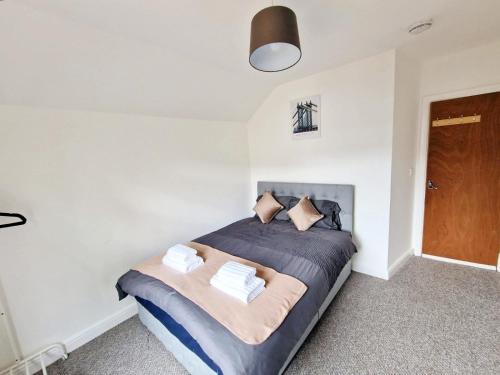 Un dormitorio con una cama con almohadas. en JPL Apartment, en Cardiff