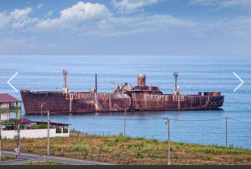 an old boat sitting on the water in the ocean at Joy Life Studio in Constanţa