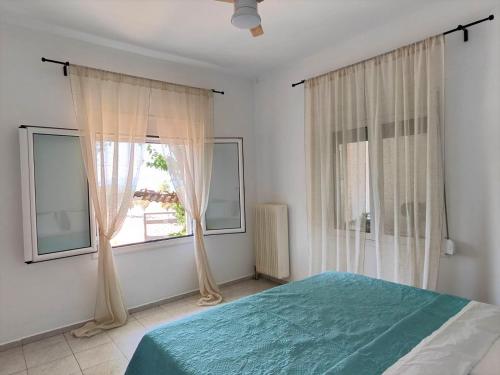 a bedroom with a bed and a large window at Asmini Beach Apartments in Asmínion