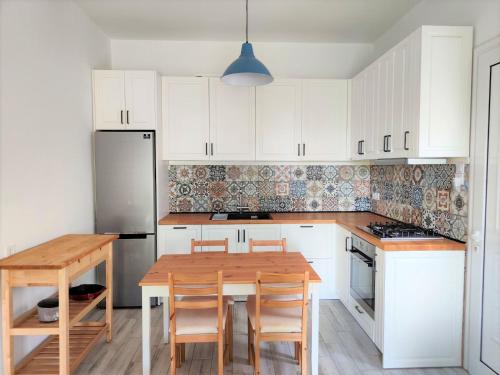 a kitchen with white cabinets and a wooden table at Asmini Beach Apartments in Asmínion