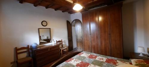 a bedroom with a bed and a dresser and a mirror at Casa Badia in Radda in Chianti