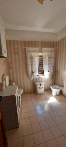 bagno con lavandino, servizi igienici e finestra di Casa Badia a Radda in Chianti