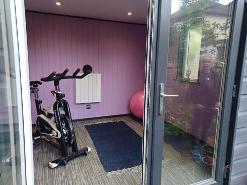 una habitación con un gimnasio con una bicicleta junto a una puerta en 46 Linden Road, en Scalby