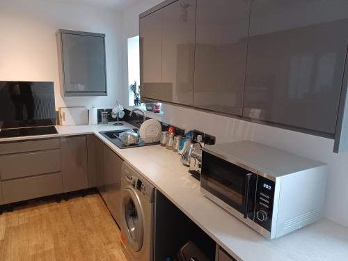 a kitchen with a microwave and a dishwasher at 46 Linden Road in Scalby