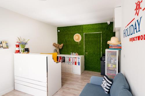 a room with a green wall and a refrigerator at Holiday Point in Międzywodzie