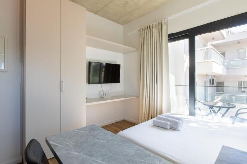 利馬索爾的住宿－YAMAS Urban LIving Spiridonos，一间卧室设有一张床和一个大窗户