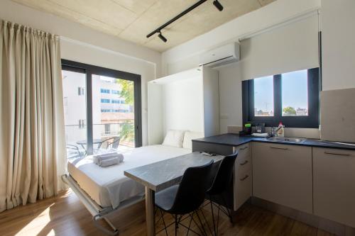 利馬索爾的住宿－YAMAS Urban LIving Spiridonos，一间卧室配有一张床铺和一张桌子,还设有一间厨房