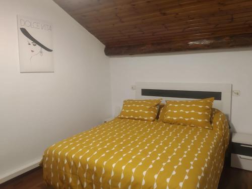 1 dormitorio con 1 cama con edredón amarillo en APARTAMENT BETTY en Sort