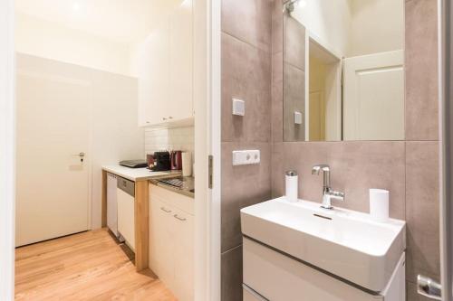 a white bathroom with a sink and a mirror at Studio Apartment Friedrichshain in Berlin