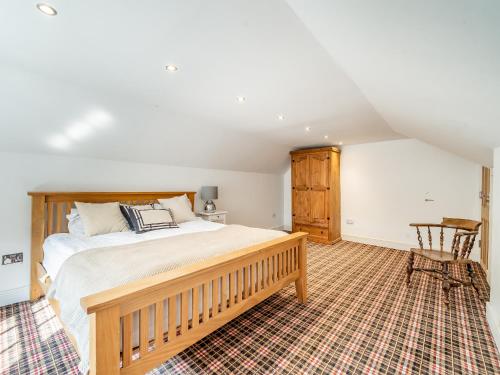 a bedroom with a large bed and a chair at The Annexe At Moulton Grange in Brixworth