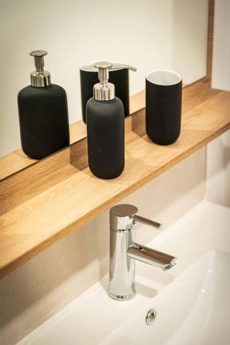 3 distributeurs de savon sur une étagère au-dessus d'un lavabo dans l'établissement L'Albatros 012 - Hypercentre * Cosy * Wifi, à Saint-Quentin