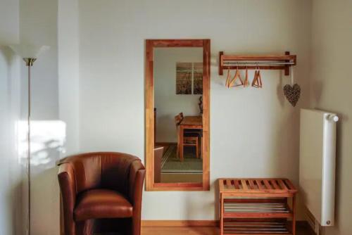 ein Wohnzimmer mit einem Stuhl und einem Spiegel in der Unterkunft Charmante 3 Zimmer WHG mit Terrasse in Scharbeutz