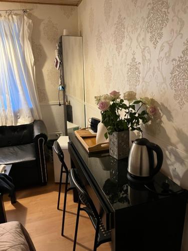 Habitación con escritorio, espejo y flores. en Accommodation en Billund