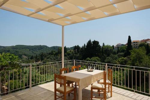 a patio with a table and chairs on a balcony at Βιλα Fiore in Avliótai