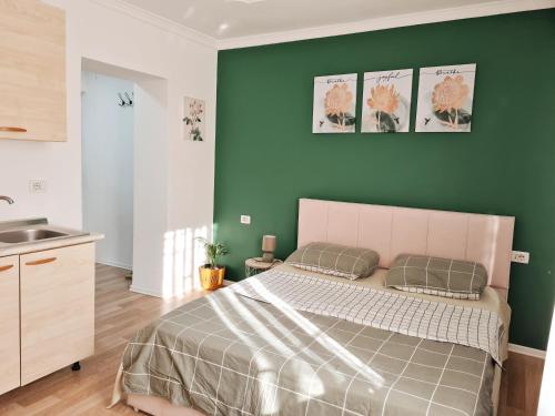 ein Schlafzimmer mit einem Bett und einer grünen Wand in der Unterkunft Casa 21 - the cutest in Tirana! in Tirana