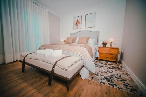 um quarto com uma cama grande e piso em madeira em Quinta D’ Aurora em Espírito Santo do Pinhal