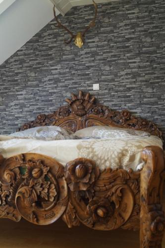 - un lit avec un cadre en bois et des fleurs dans l'établissement Ferienwohnung im Grünen, à Geldern