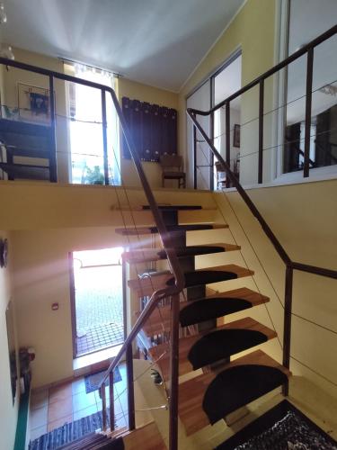 a spiral staircase in a house with two windows at Zaļais namiņš in Ventspils