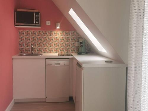 a kitchen with a sink and a microwave at Cabourg cosy, appartement refait à neuf, 5 min à pied de la mer in Cabourg