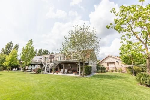 een uitzicht op een huis met een grote tuin bij B&B Het Eycken Huys in Aalter